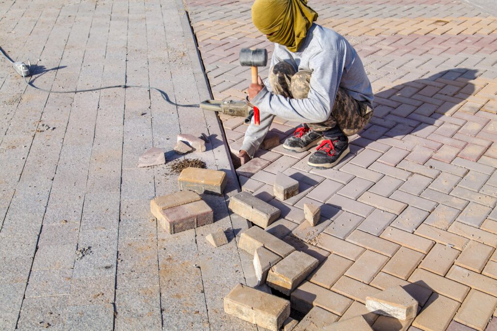 worker-set-up-panel-road-with-rubber-hammer-min